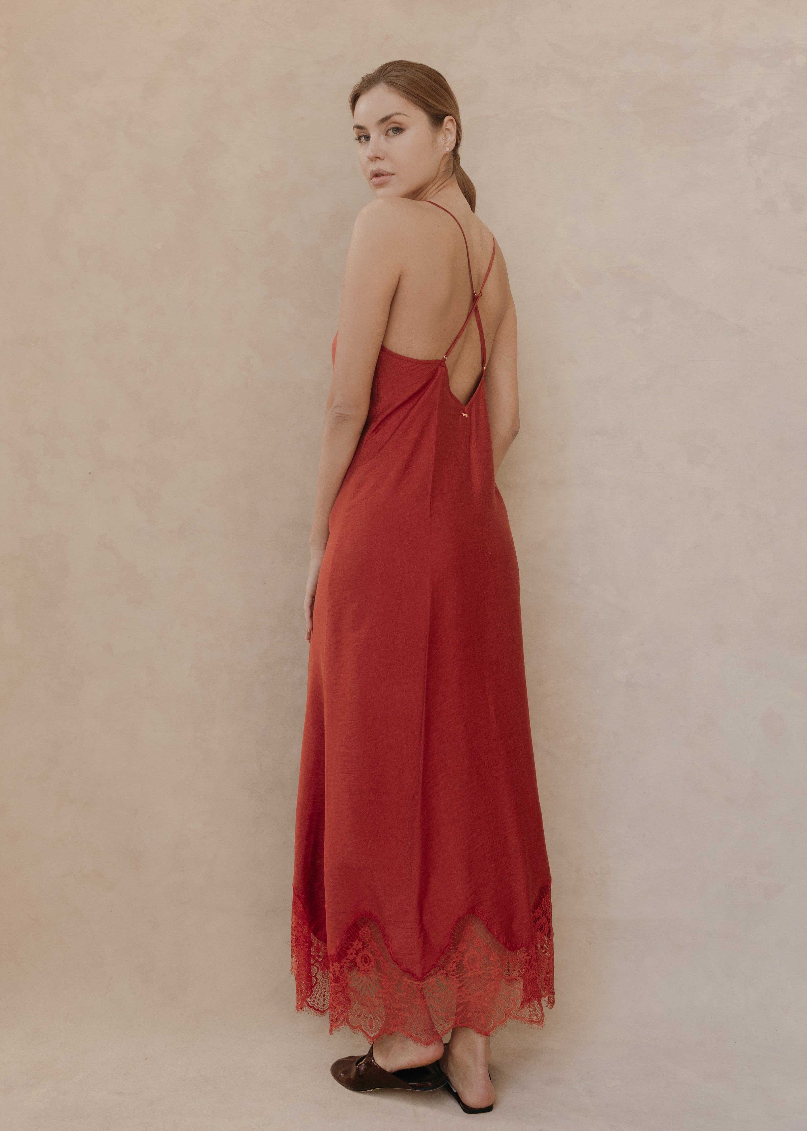 Modelo con Vestido Seraphine midi color ladrillo, vista posterior con tirantes cruzados