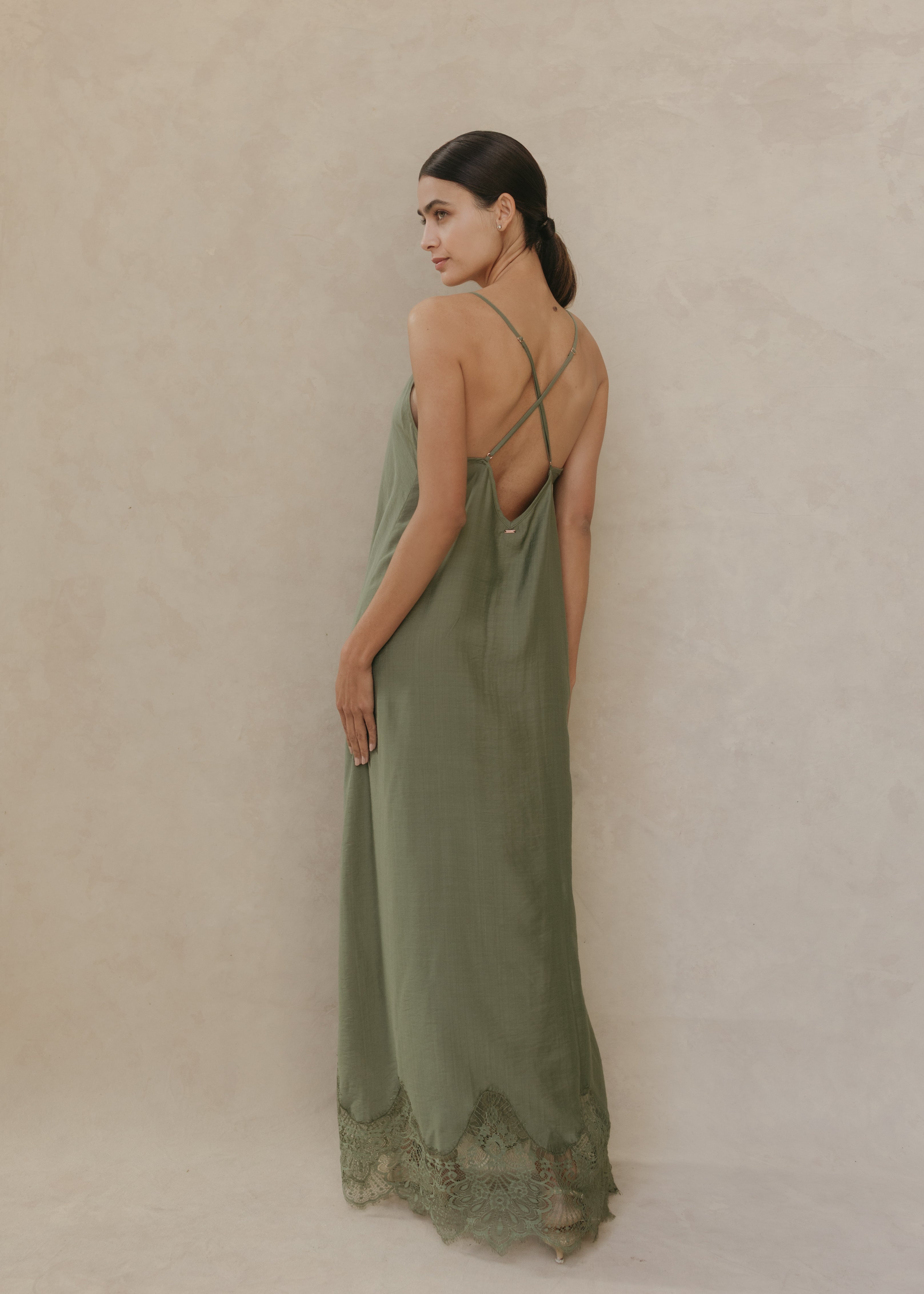 Modelo con Vestido Seraphine midi color verde olivo, vista posterior con tirantes cruzados