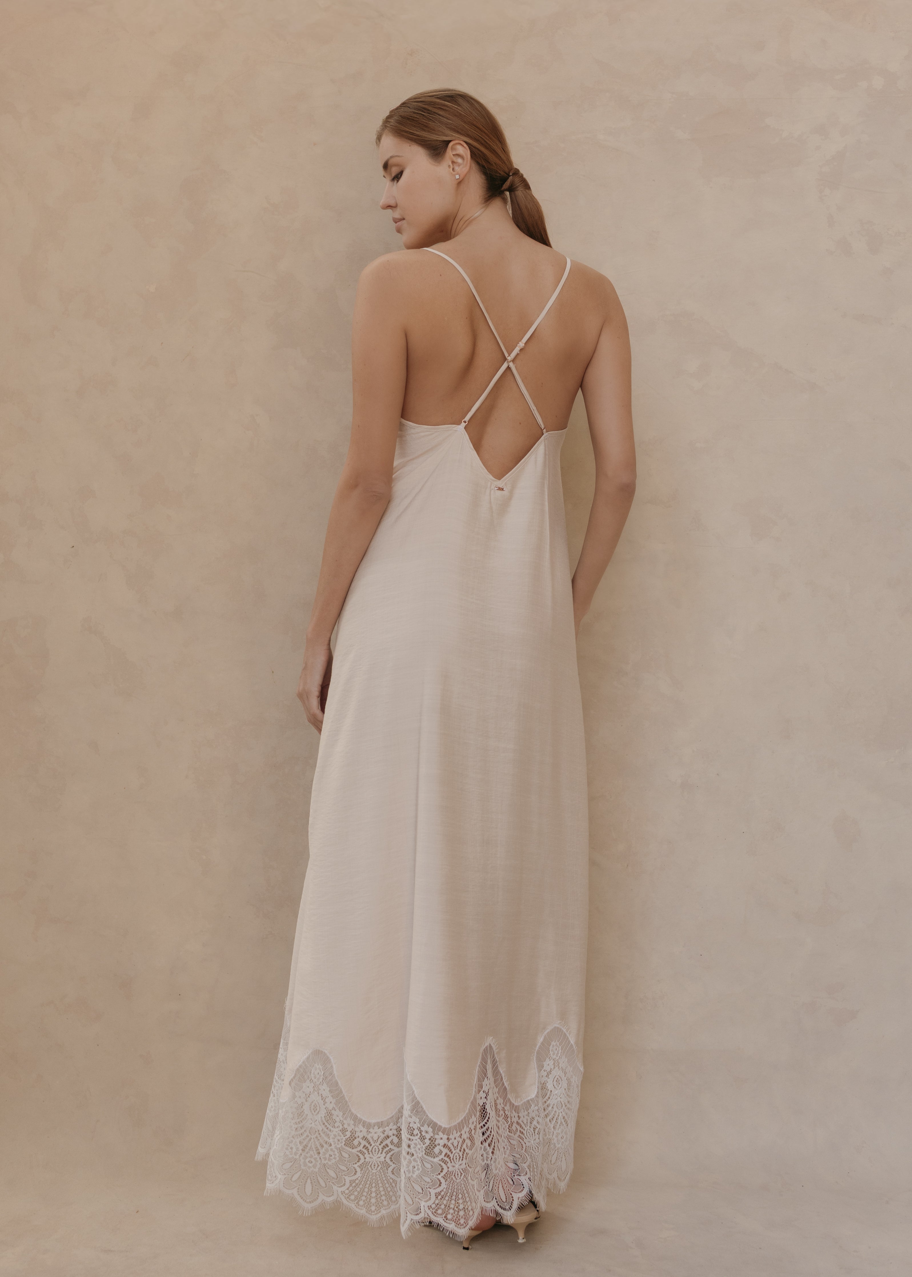 Modelo con Vestido Seraphine midi color ivory, vista posterior con tirantes cruzados